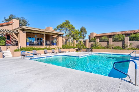 A pool with lounging chairs.