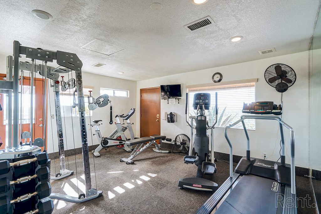 a home gym with exercise equipment and a window