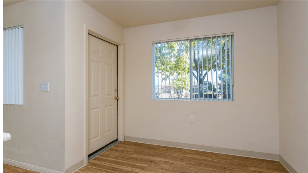 an empty room with a window and a door