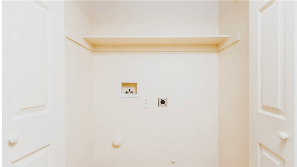 a white wall with two electrical outlets and a white door