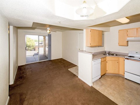 an empty kitchen and living room with a door to a balcony