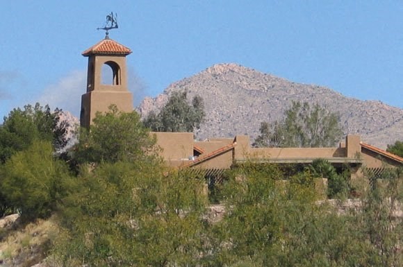 a church with a bell tower and a weather vane