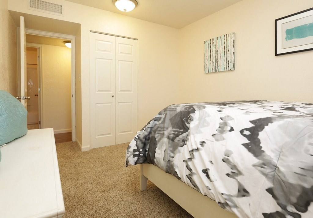 a bedroom with a bed and a door to a bathroom