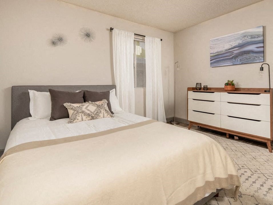 a bedroom with a large bed and a dresser