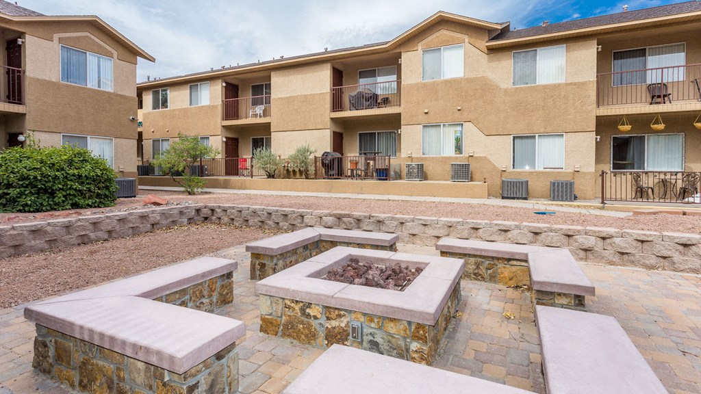 a courtyard with a fire pit in front of an apartment building