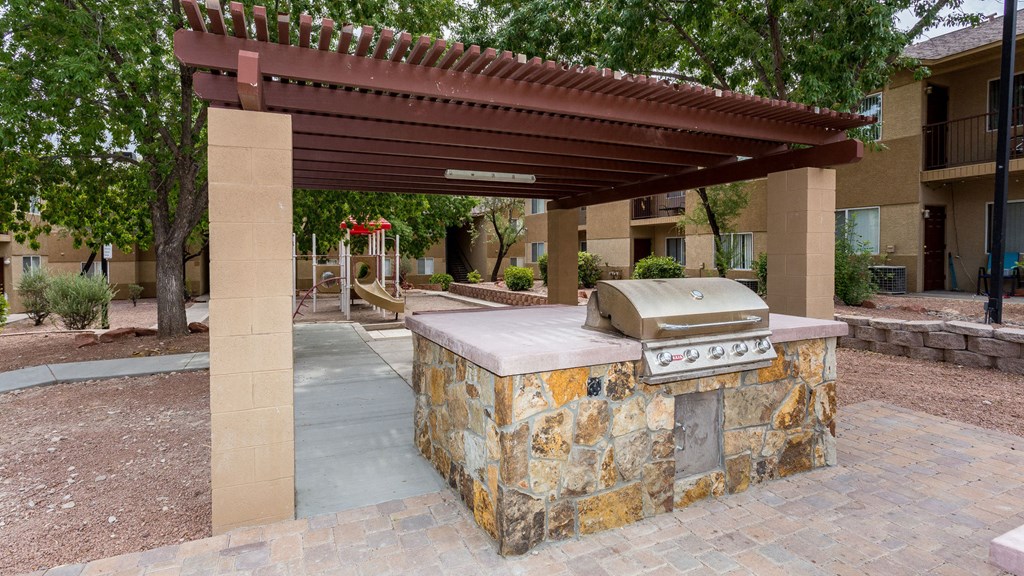 a covered outdoor kitchen with a grill