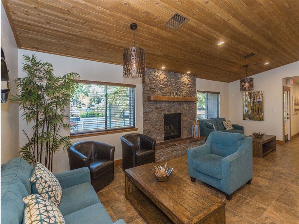 a living room with blue couches and chairs and a fireplace