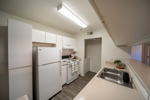 A kitchen with white appliances and a white counter top.