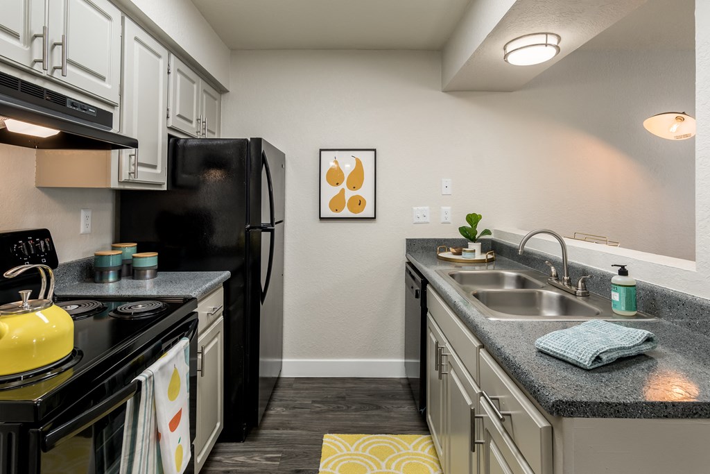 a kitchen with white cabinetry and black appliances