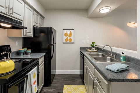 a kitchen with black appliances and granite counter tops