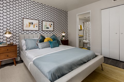 A bedroom with a bed and two night stands.