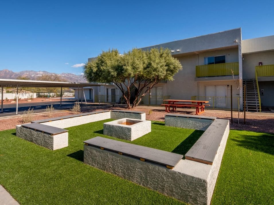 picture of the backyard of a house with a fire pit and a picnic table