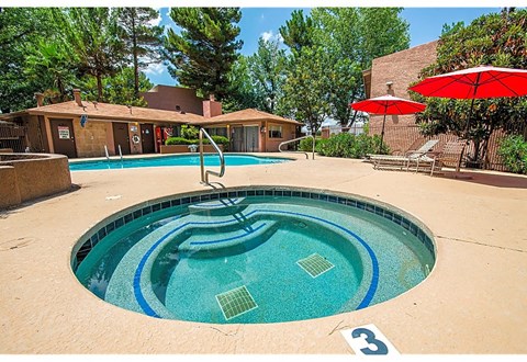 a pool with a slide and a hot tub in front of a building