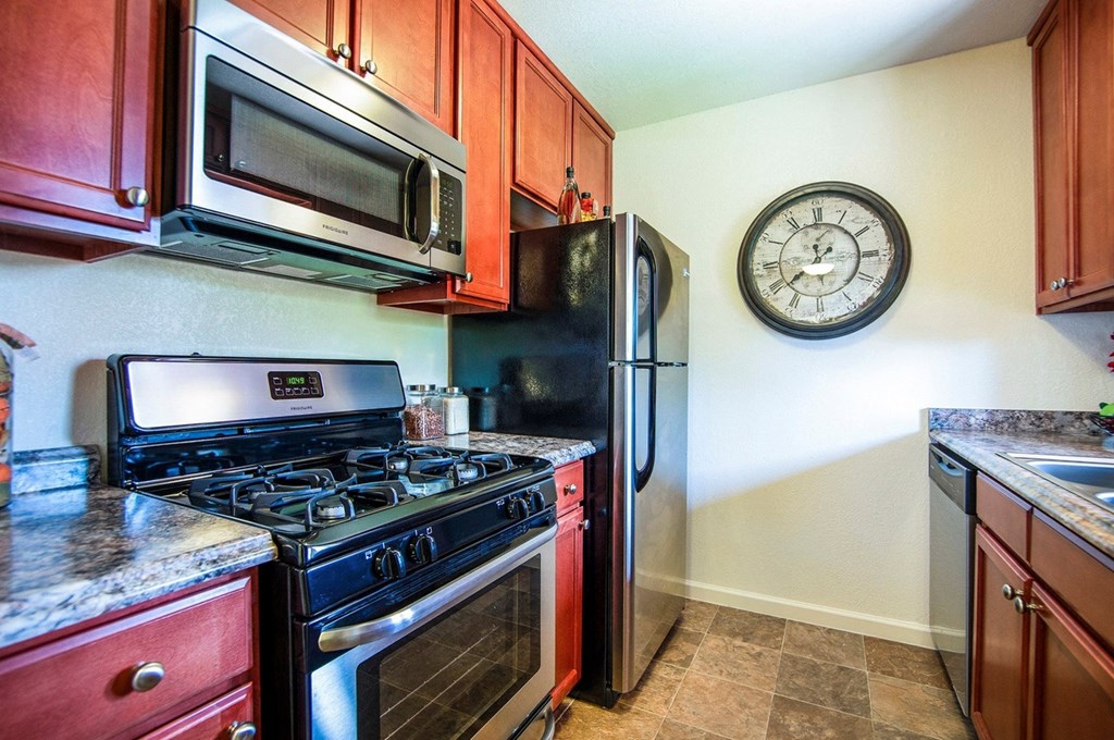 a kitchen with stainless steel appliances and a clock