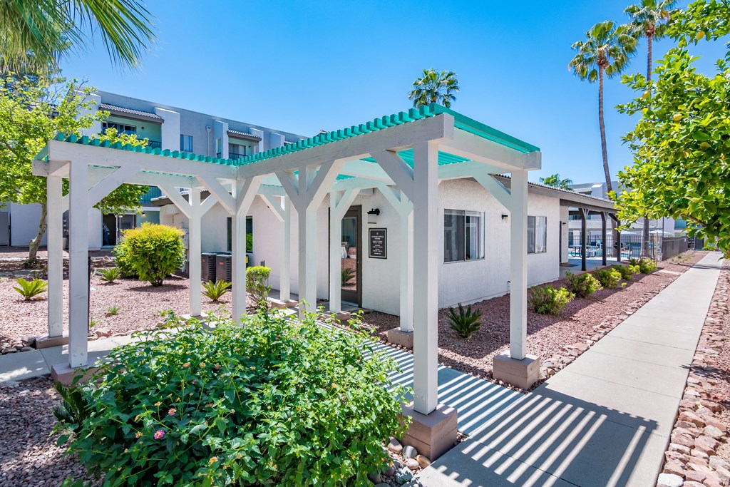 a white building with a green roof and a blue sky in the background