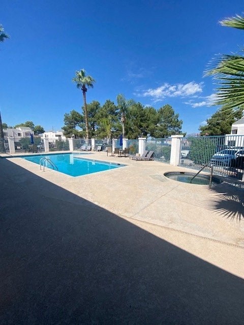 a swimming pool with palm trees and a fence around it