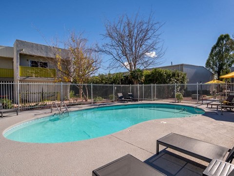 a pool with a fence around it and a building in the background