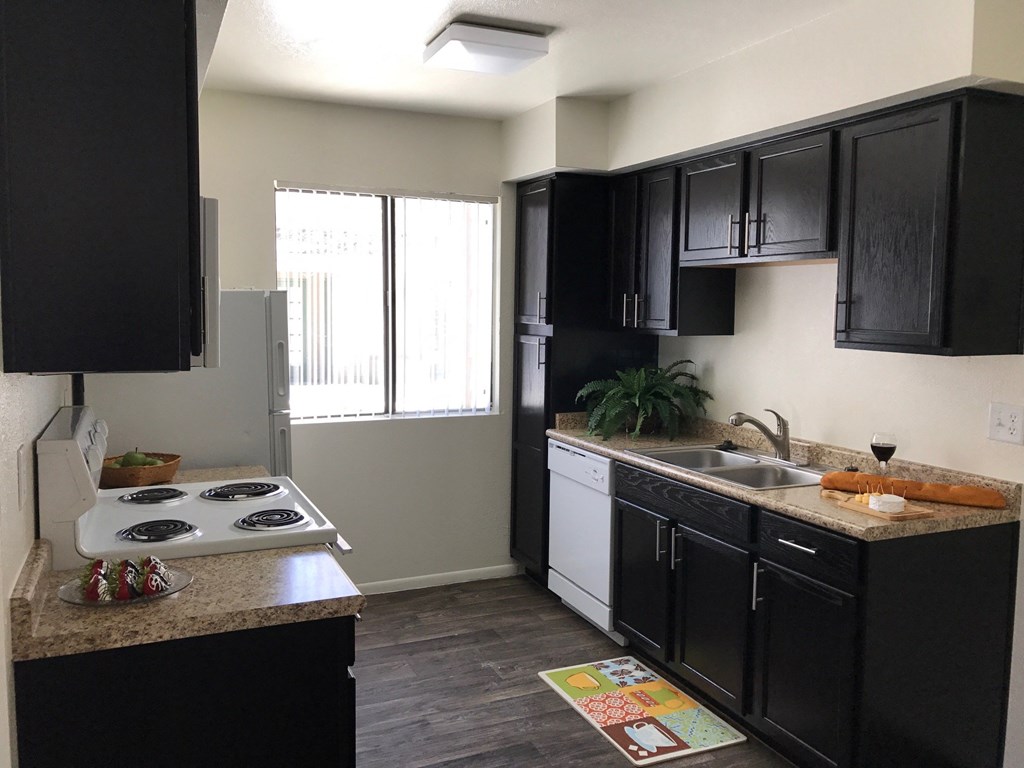 a kitchen with black cabinets and white appliances