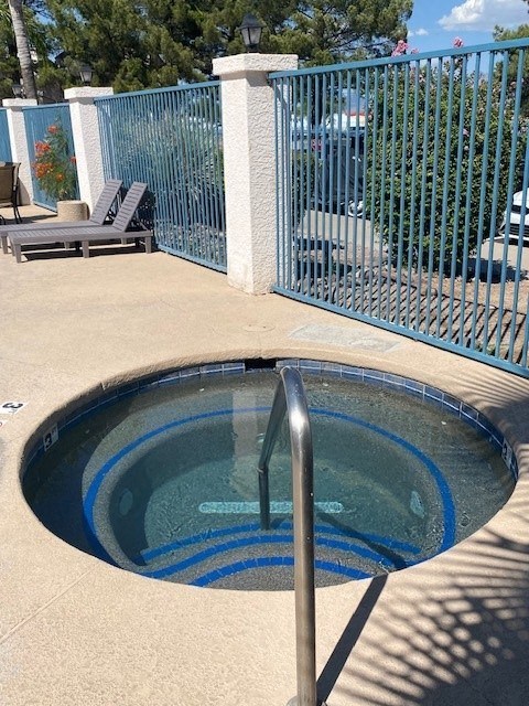 a small pool in the middle of a patio with a fence