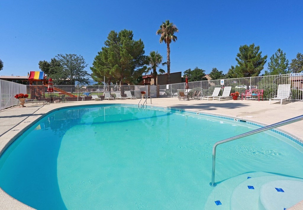 a swimming pool at an apartment community with palm trees