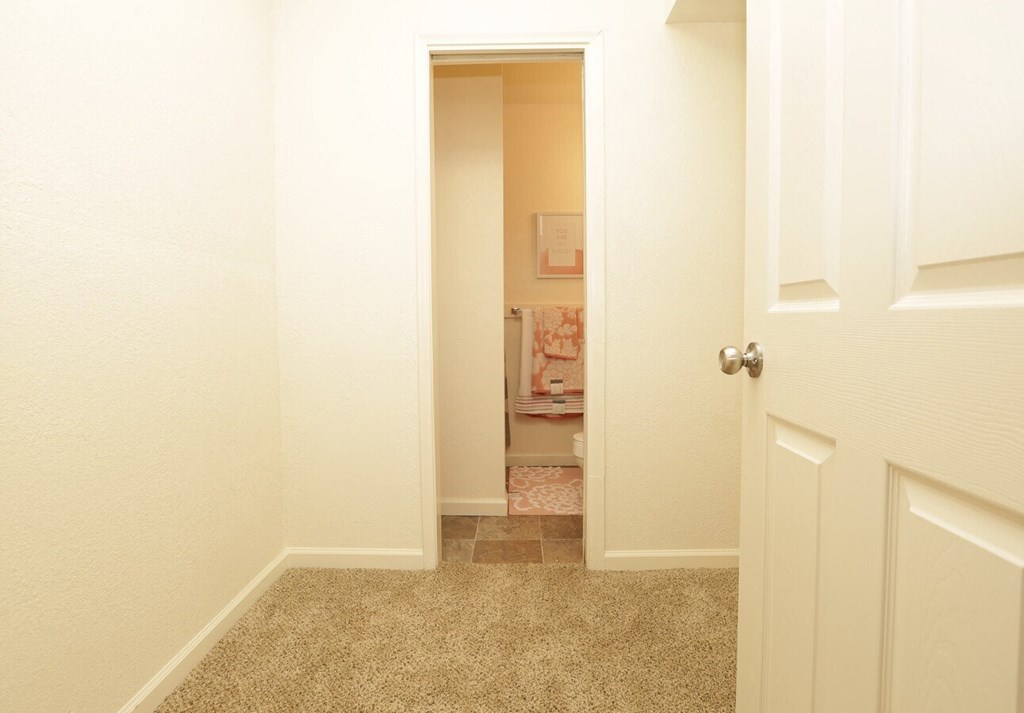 walk-in closet with a view toward a private bathroom