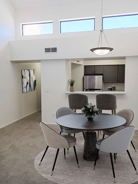 A modern dining room with a round table and chairs.