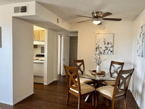 a dining room with a table and chairs and a ceiling fan