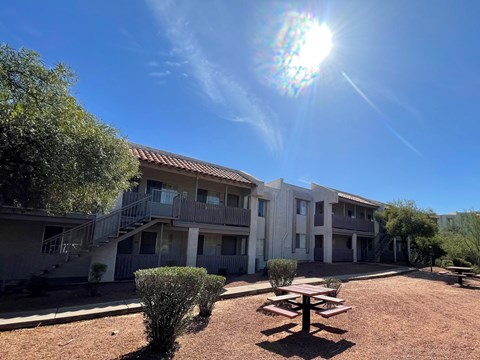 a courtyard with a picnic table and picnic table in front of a building