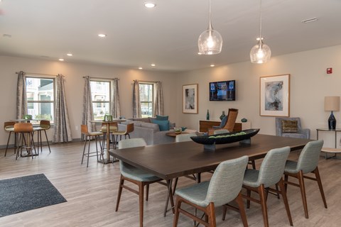 A modern dining room with a large table and chairs.