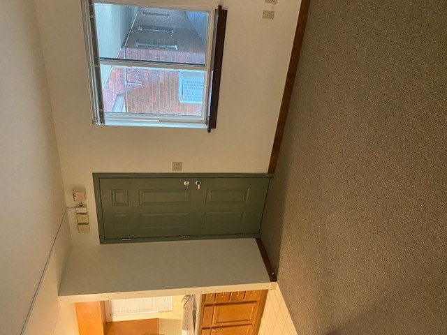 a small room with a desk and a window