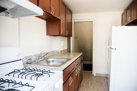 an empty kitchen with a stove and a sink