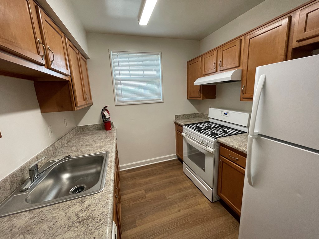 a kitchen with wood flooring and white appliances