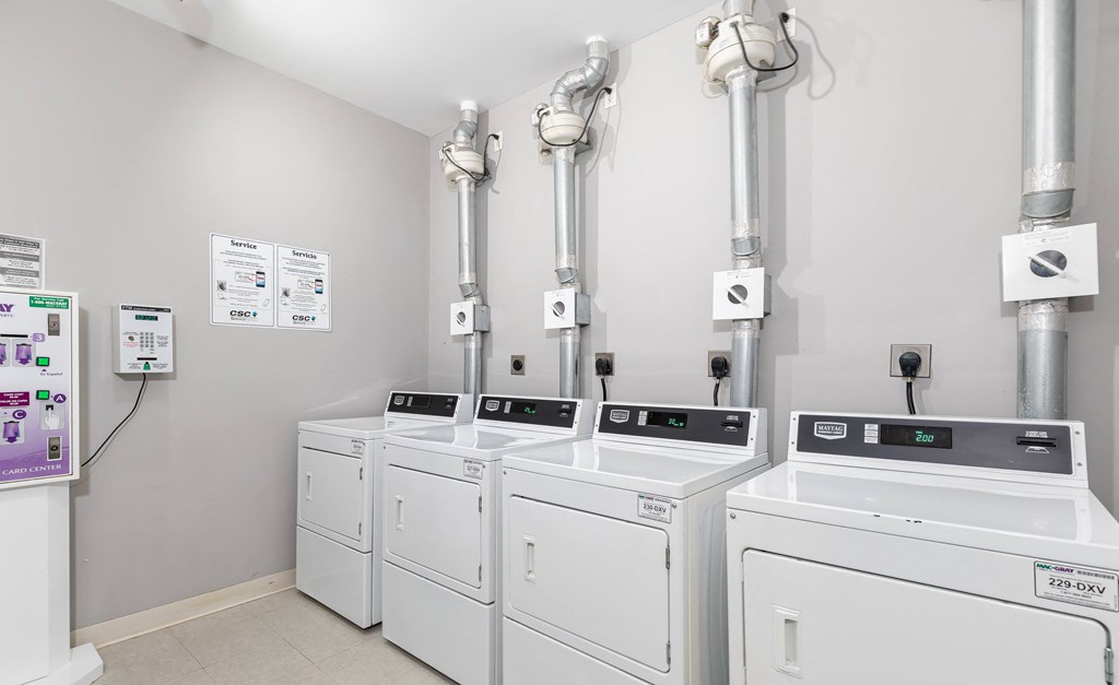 a row of washers and dryers in a laundry room