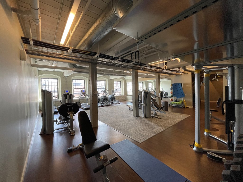 a gym with fitness equipment and windows in a building
