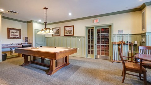 A room with a pool table and a chair.