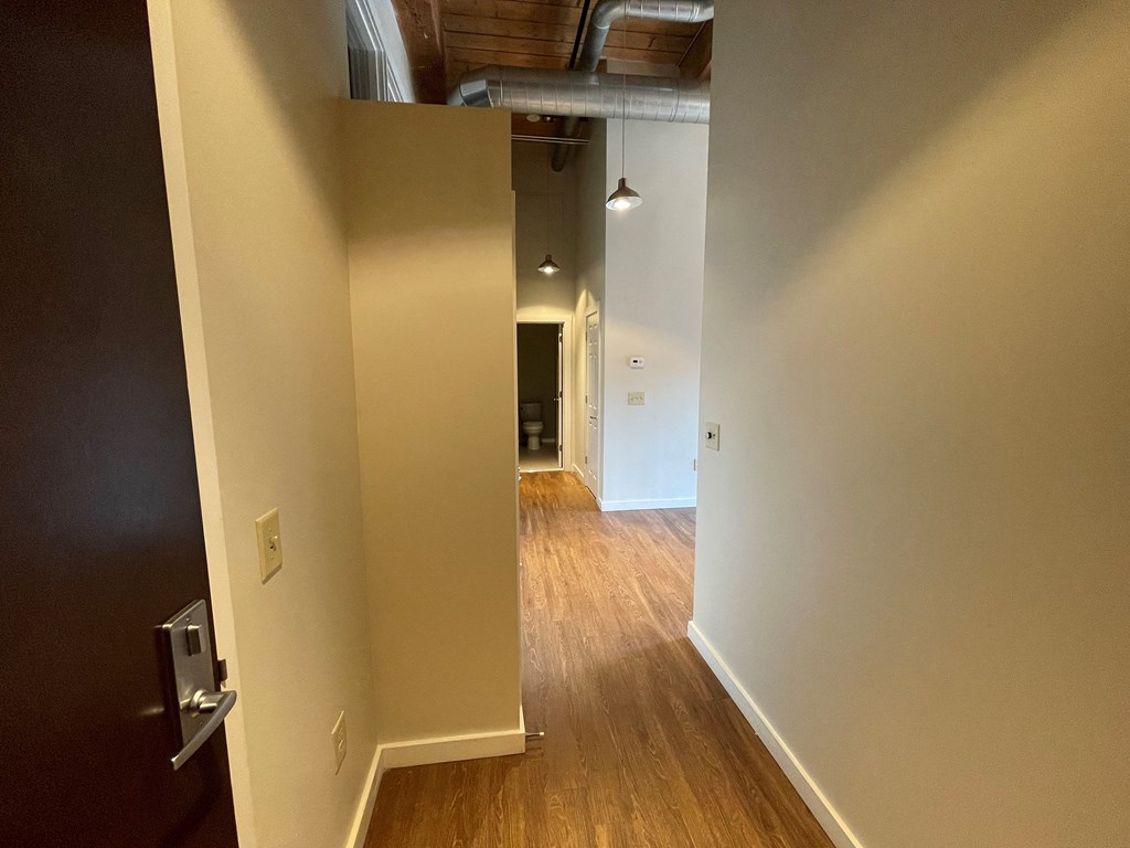 a view of a living room from the hallway of a home with a wood floor