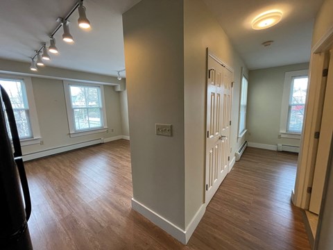 a dining room and living room with wood floors and white walls