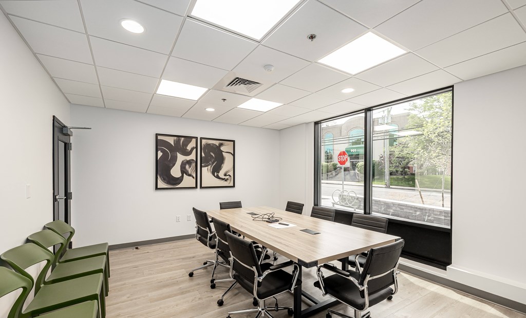 A conference room with a long table and chairs.