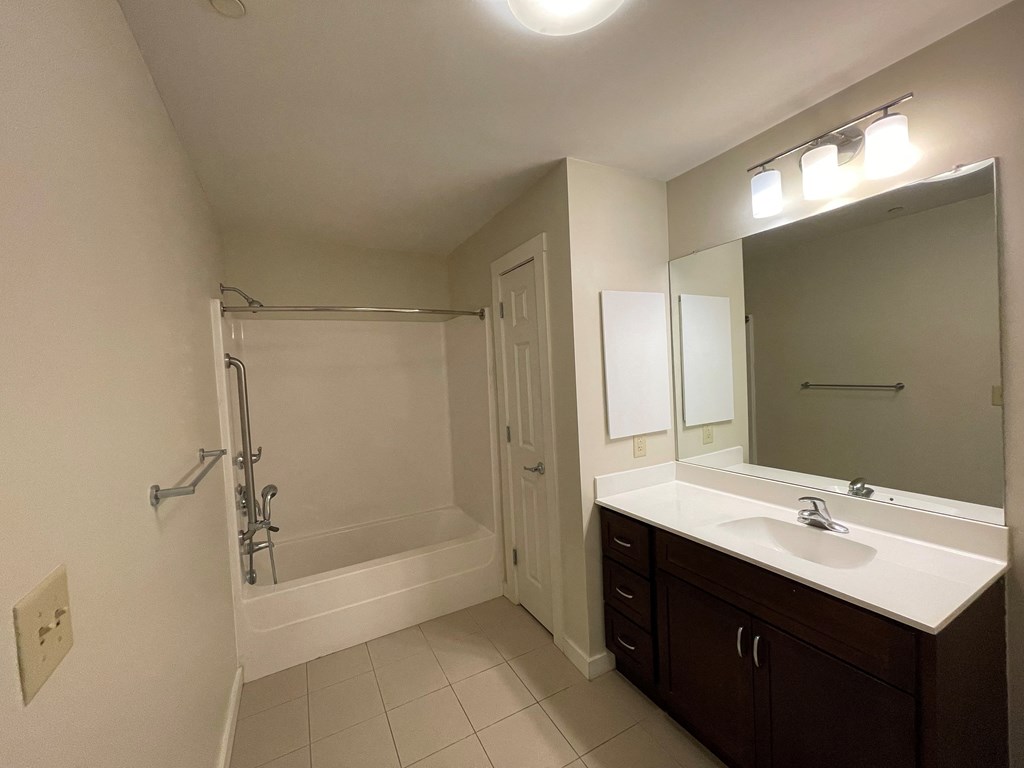 a bathroom with a sink and a shower and a mirror