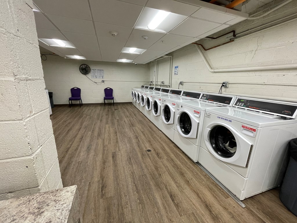 a large laundry room with washers and dryers