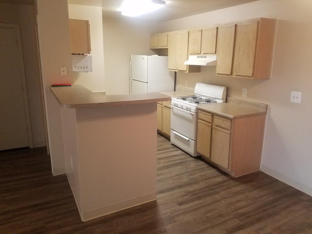 an empty kitchen with a stove and a refrigerator