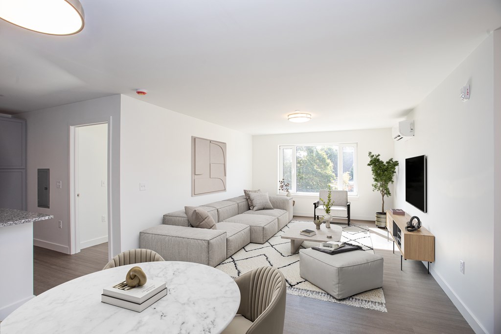 A living room with a white marble table and a grey couch.