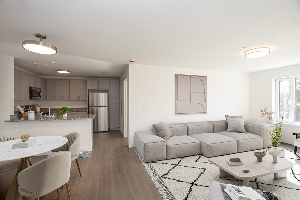 A modern living room with a grey sofa and a white coffee table.