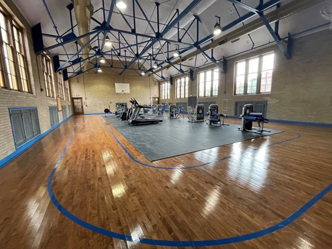 a gym with a hard wood floor and gym equipment