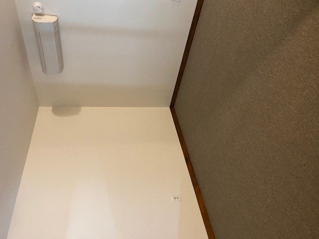 a room with a white floor and a light on the wall