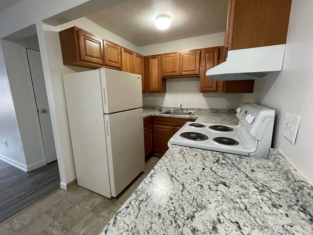 a kitchen with a white refrigerator and a counter top with a stove and a refrigerator