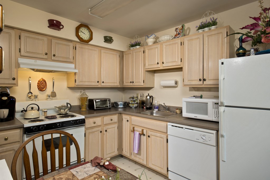 a kitchen with white appliances and wooden cabinets