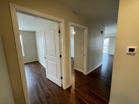 a living room with a door open to a hallway and a door to a bedroom