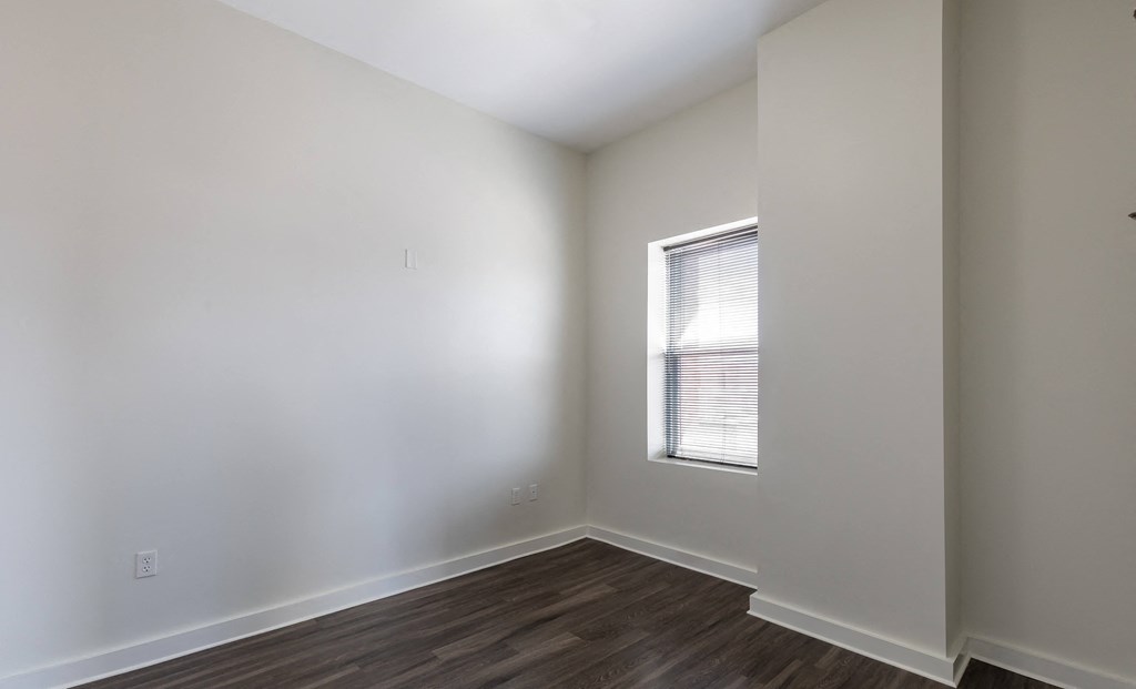 an empty room with white walls and a window
