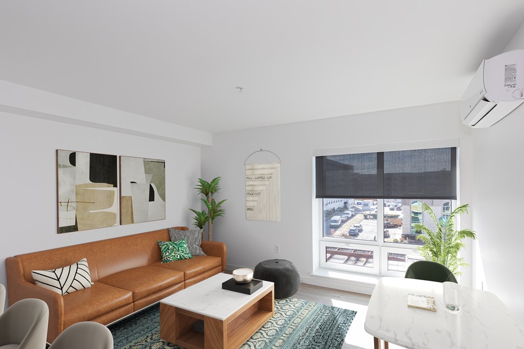 A living room with a brown couch, a white chair, and a coffee table.